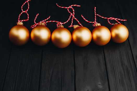 Colored christmas decorations on black wooden table. Xmas balls on wood background. Top view, copy space. new year