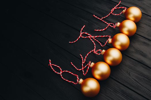 Colored christmas decorations on black wooden table. Xmas balls on wood background. Top view, copy space. new year