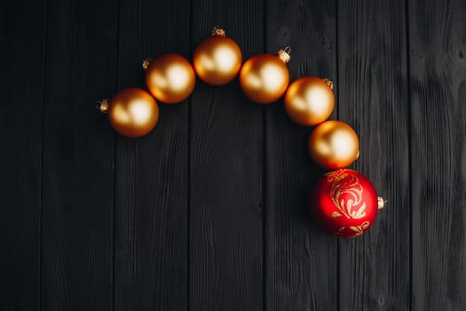 Colored christmas decorations on black wooden table. Xmas balls on wood background. Top view, copy space. new year