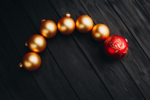 Colored christmas decorations on black wooden table. Xmas balls on wood background. Top view, copy space. new year