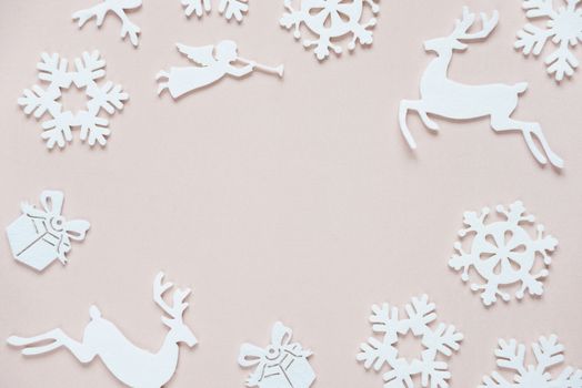 Christmas frame composed of white christmas decoration: snowflakes, deers, flying angel and gift boxes on pink background. Flat lay composition for websites, social media, business owners, magazines,  bloggers, artists etc.