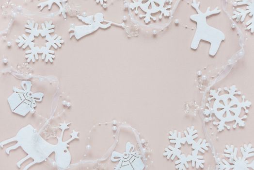 Christmas frame composed of white christmas decoration: snowflakes, deers, flying angel and gift boxes on pink background. Flat lay composition for websites, social media, business owners, magazines,  bloggers, artists etc.