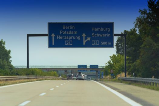 German motorway sign with inscription in German direction arrow to the cities - Berlin, Potsdam, Herzsprung, Hamburg and Schwerin