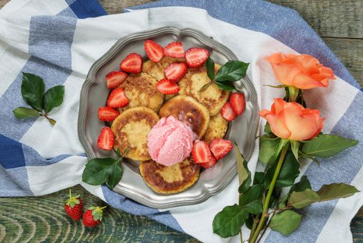 Breakfast of pancakes with ice cream and ripe berries of strawberry, top view