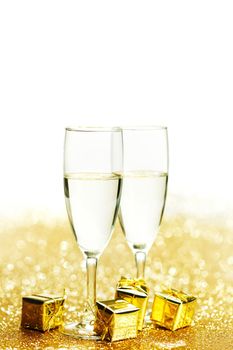 Champagne glasses and gifts on glitters with white copy space