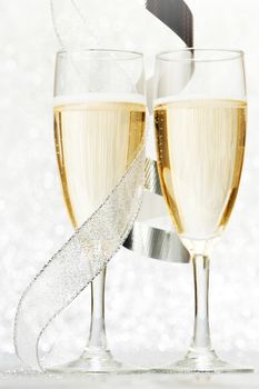 Champagne and gift ribbon on silver bokeh background