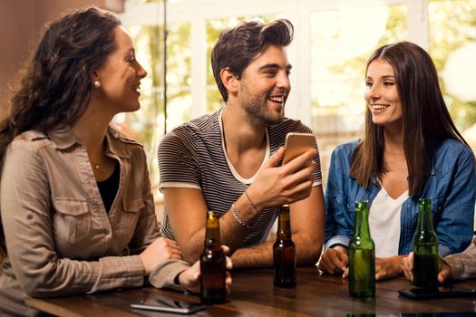 A group of friends at the bar drinking a beer 