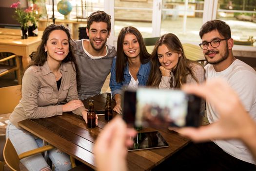 Taking a photo of a group of friends at the bar 