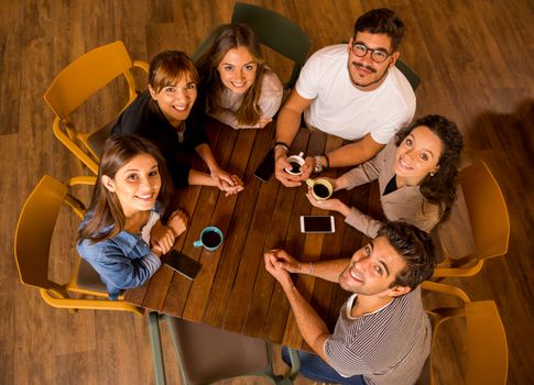 A group of friends drinking coffee at the cafe and looking up 