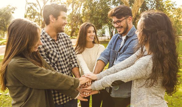 Group of friends joining their hands together