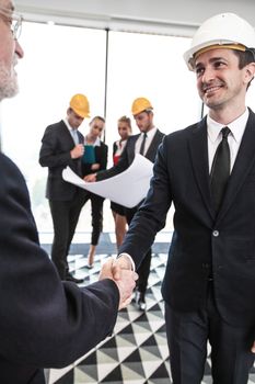Business meeting of architects and investors shaking hands in office