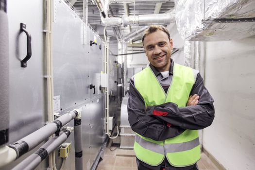 Portrait of smiling worker in electrical switchgear room of CNC plant