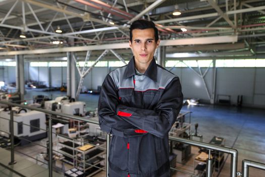 Portrait of young worker standing at CNC factory