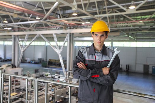 Portrait of young worker with wrench at CNC factory