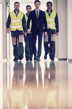 Business people and workers moving along the corridor at factory