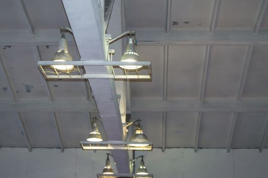 Lighting with lamps located on the ceiling in an industrial room.