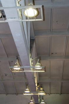 Lighting with lamps located on the ceiling in an industrial room.