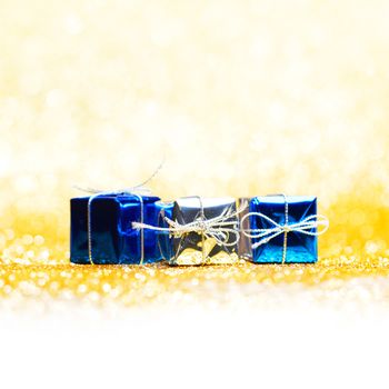 Blue holiday gifts on golden glitter background