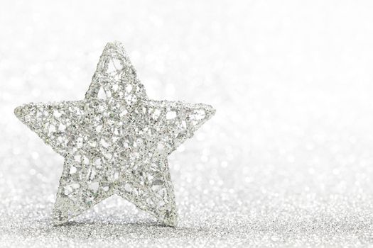 Christmas decorative star on light silver bokeh background