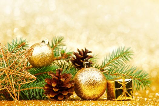 Christmas card with fir branch and decorations on golden gitter background