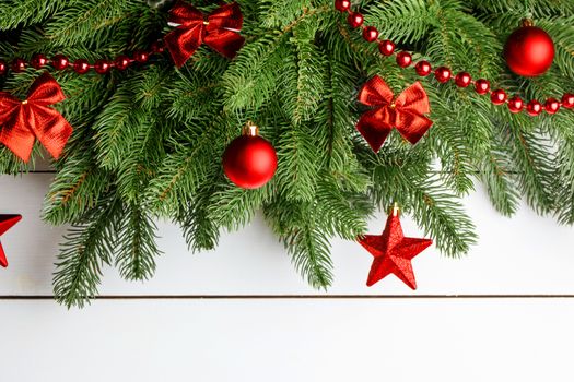 Christmas tree decoration frame on wooden background , fir tree branch , red baubles , copy space for text