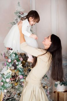 Happy mother and her little daughter at Christmas decorated home