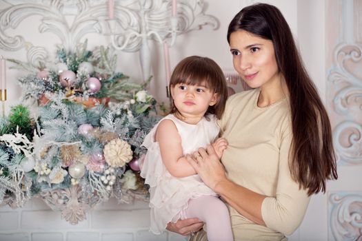 Happy mother and her little daughter at Christmas decorated home