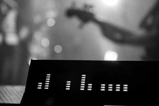 Monochrome Pro Audio Mixing Console with Bass player in Background, performing at live festival event