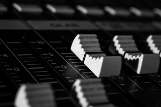 Closeup view of Faders on Professional digital Audio mixing control Console with zero decimal indicators