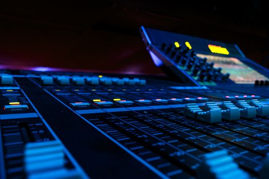 Wide angle closeup of Pro Audio Digital Mixing Console. White Faders and black control Console