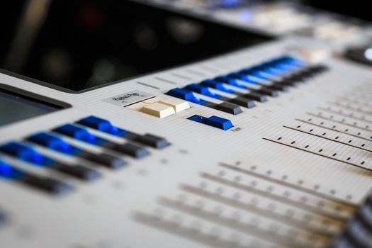 Digital Display and control Faders on Professional Lighting Designers Programming desk, controller Console, white desk and grey Faders