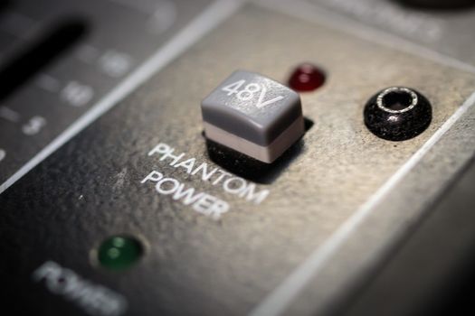 grey 48volt phantom power selector switch on a professional audio mixing console