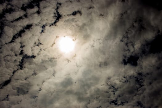 Dark black sky with scattered fluffy clouds