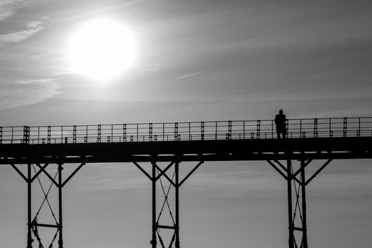 Monochrome single man thinking on an old english victorian seaside pier