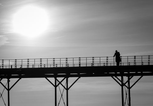 Monochrome single man thinking on an old english victorian seaside pier