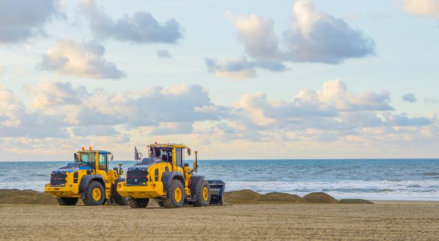 earthmoving equipment machines working at the beach for maintenance moving sand industrial agriculture
