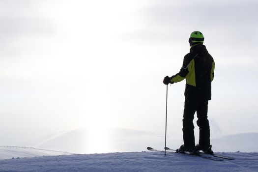 Skier on ski slope with mountains in background