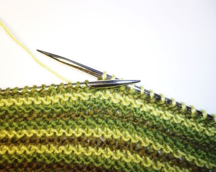 Knitting. Knitted fabric and knitting needles. Work process. Hobbies leisure crafts