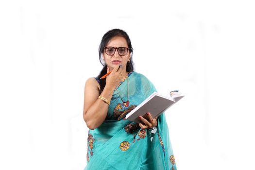An Indian teacher in Blue Saree asking a question to students, on white studio background.