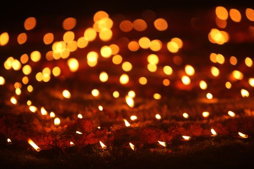 Beautiful earthen traditional lamps put in a garden lawn during Diwali festival celebration, in India.