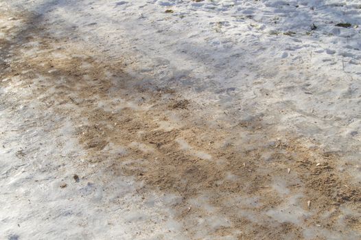 Ice track, sanded, removes ice slippery road close up.