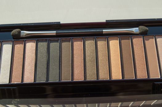 Cosmetic palette with brush and eye shadow with light brown, beige and Nude eyeshadow.