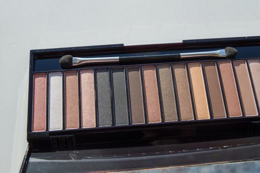 Cosmetic palette with brush and eye shadow with light brown, beige and Nude eyeshadow.