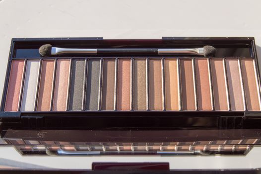 Cosmetic palette with brush and eye shadow with light brown, beige and Nude eyeshadow.