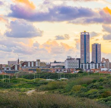 Popular and touristic location Scheveningen The netherlands a town near the beach at sunset view from the dunes on the buildings and skyscrapers