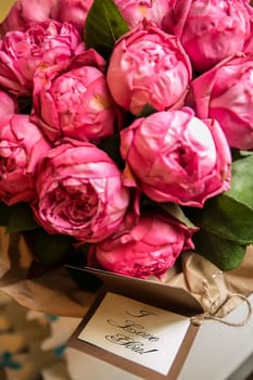 Bouquet of peony roses with letter and note saying - I love you