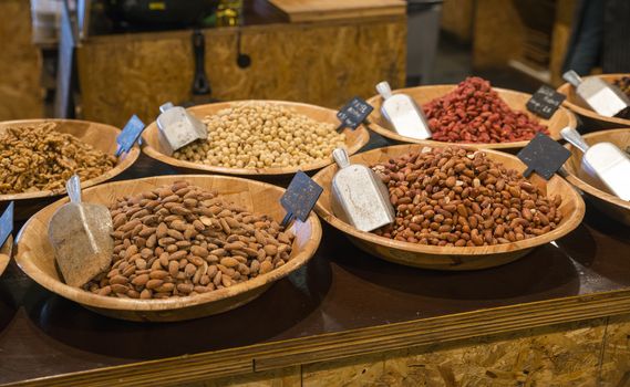 desk in a shop with peanuts walnuts hazelnuts and other nuts for selling and consumption