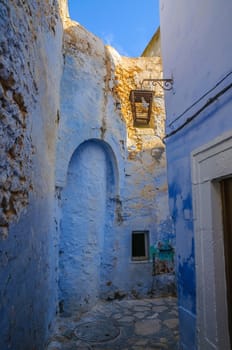 Oriental narrow street with blue houses in Medina, Hammamet Tunisia.