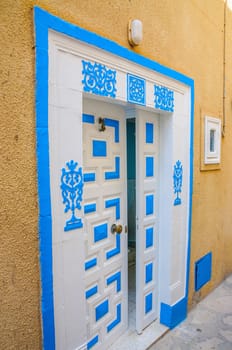 Oriental white blue door with ornament in Hammamet Tunisia.