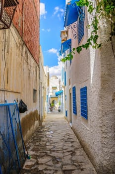 Narrow street with white houses in Hammamet Tunisia.